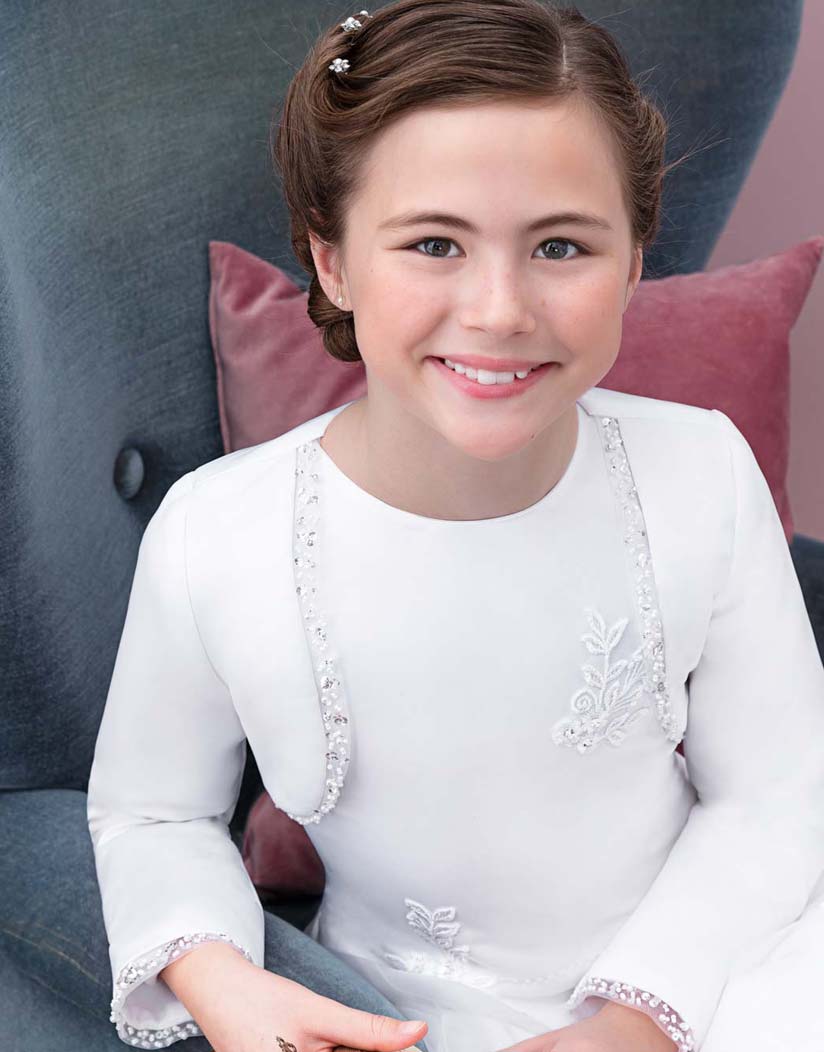 Mädchen lacht und trägt ein Bolero mit Glitzersteinen